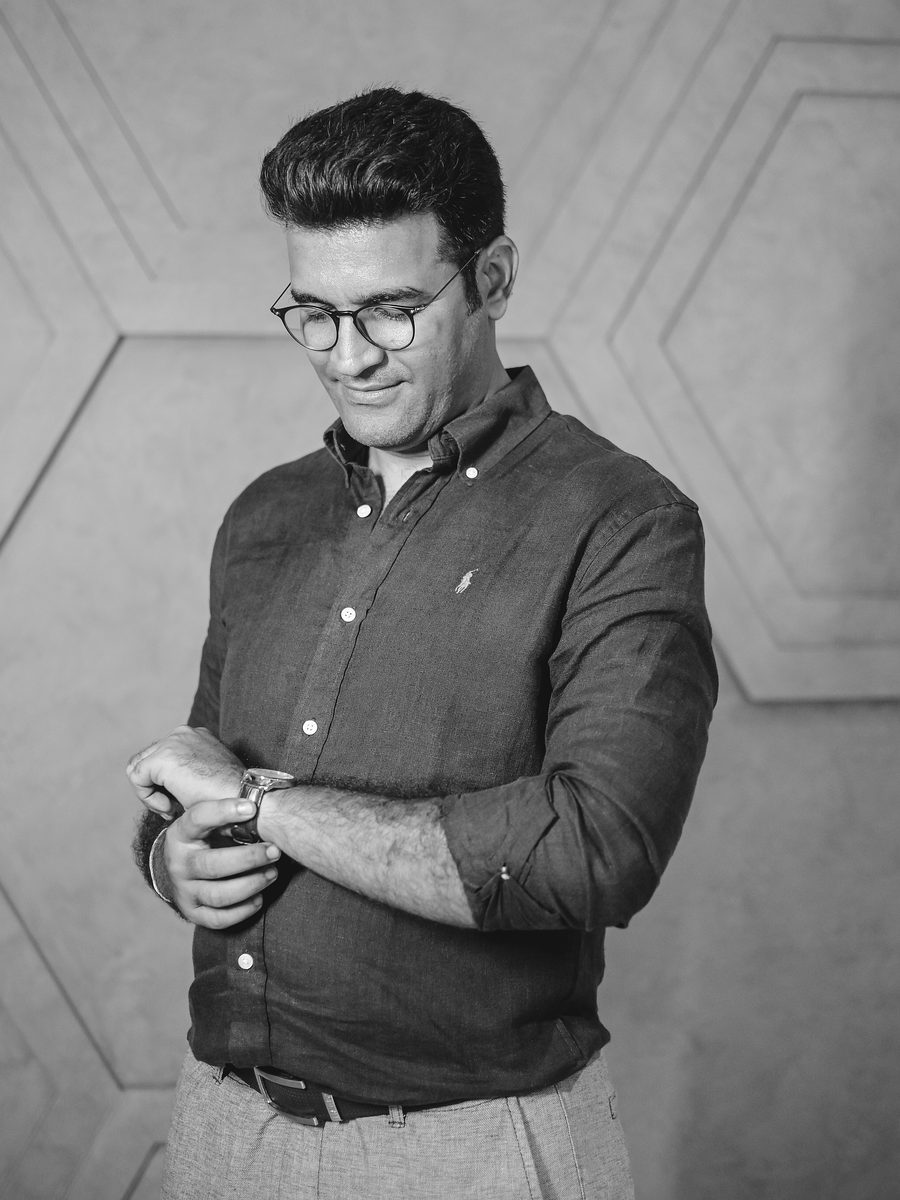 Mehul Dedhia in a dark linen shirt, adjusting his watch